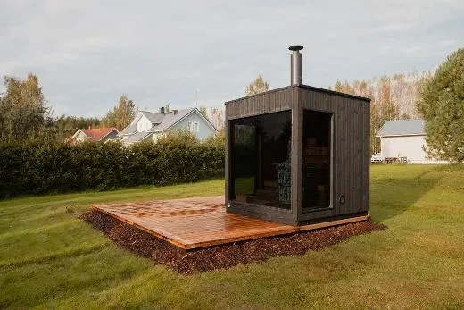 Atmospheric evening light reflects off the thermowood patio surface.