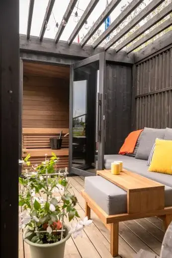 Kirami FinVision® -pergola Misty, decorate with a sofa.